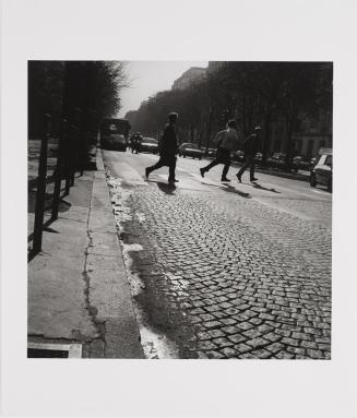 Paris [three people running across cobblestone street]